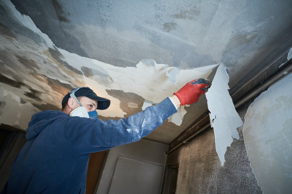 Restoration contractor working on a damaged ceiling.